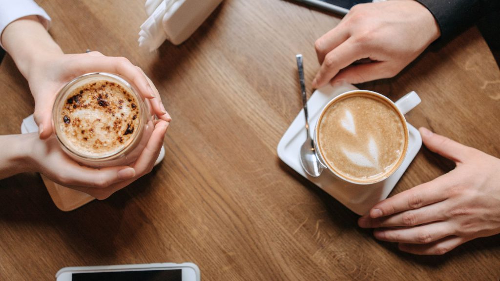 Two people having a conversation while having coffee.
